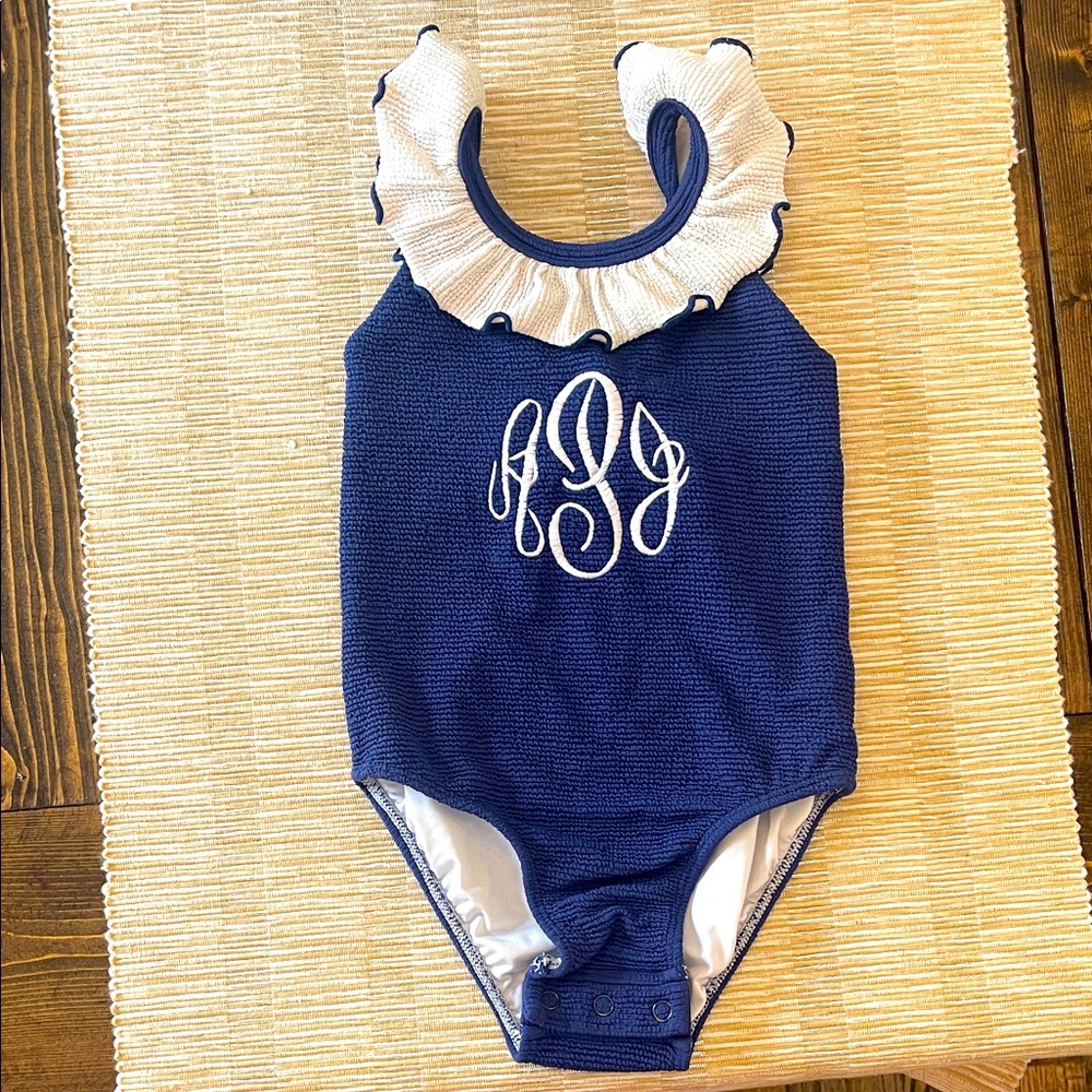 Navy Blue swimsuit with White Ruffle and snaps. Monogrammed with: APJ.